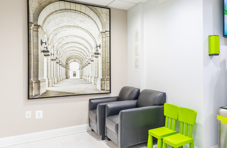 a living room with a couch, chair, and a painting  at RTC Dental in McLean for Invisalign Reston services.