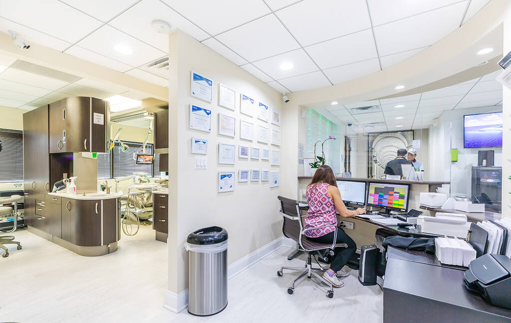 a woman sitting at a desk in a cubicle  at RTC Dental in Great Falls for Reston dental office services.