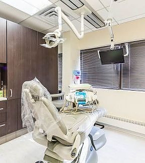 a hospital room with a bed and a monitor  at RTC Dental in Ashburn for RTC Dental Reston services.