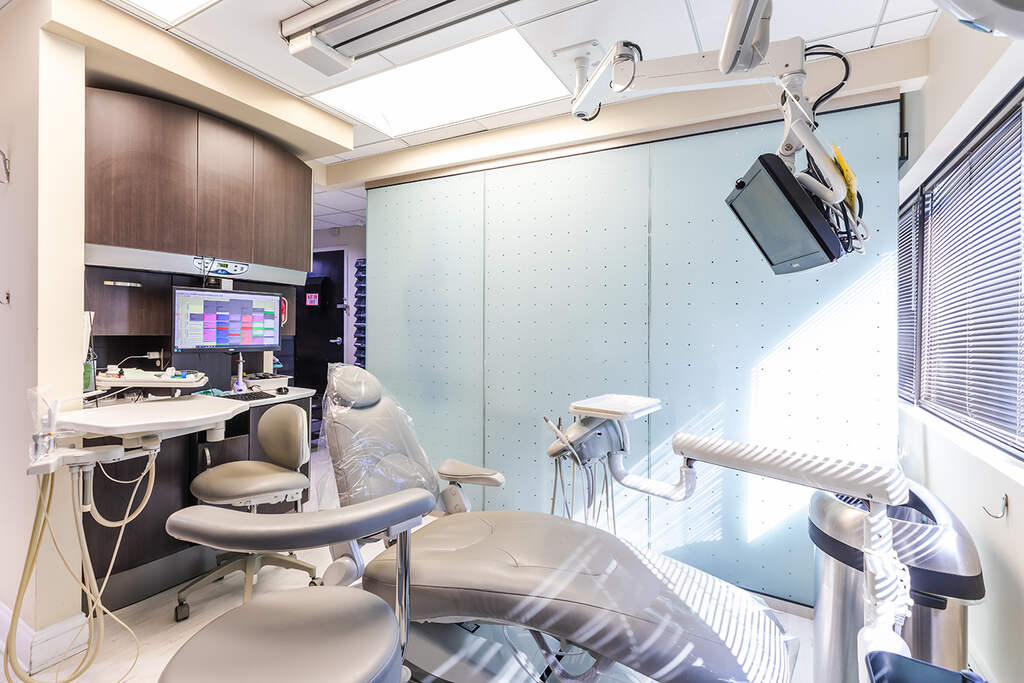 a bathroom with a sink, mirror, and a chair  at RTC Dental in Oakton for Dental implants Reston services.