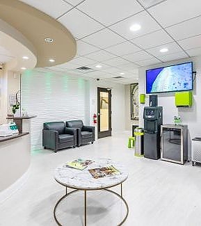 a living room with a couch, table, and a tv  at RTC Dental in Chantilly for Pediatric dentist Reston services.