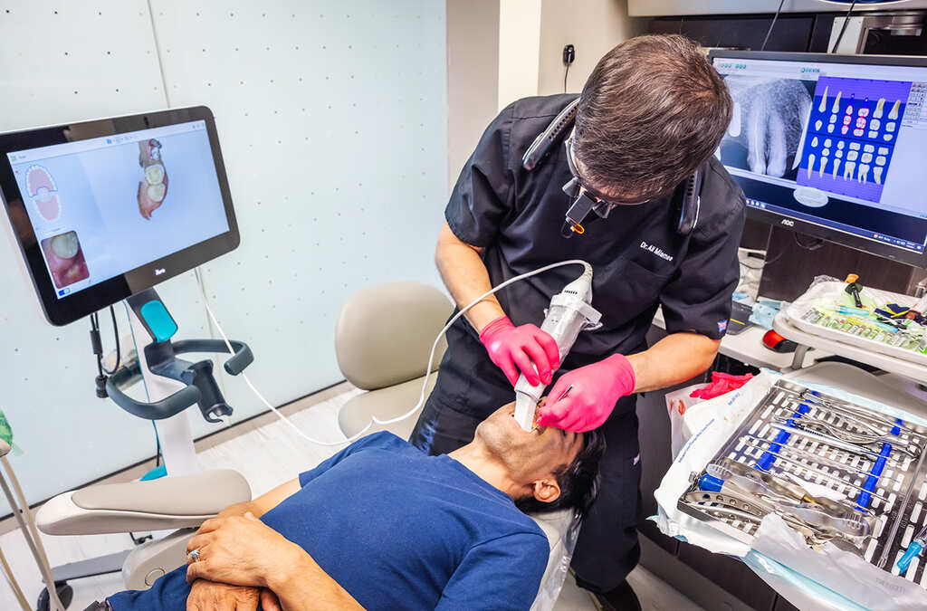 a man is putting a mask on a man's face  at RTC Dental in Arlington for Teeth whitening Reston services.