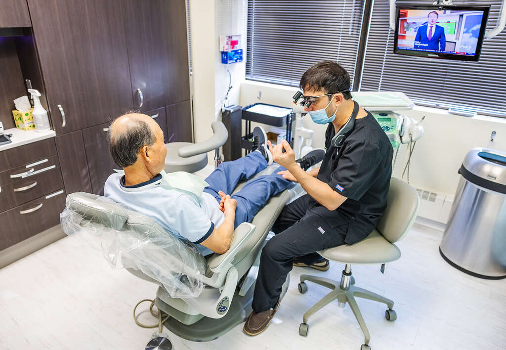 a man sitting in a chair with a woman  at RTC Dental in Oakton for Dental implants Reston services.