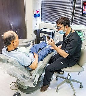 a man sitting in a chair with a woman  at RTC Dental in Oakton for Dental implants Reston services.