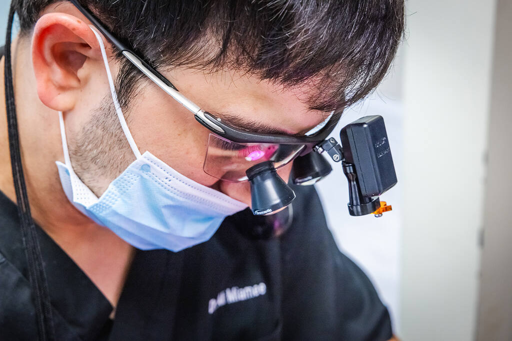 a man with a bandana and goggles on is using a cell phone  at RTC Dental in Arlington for Teeth whitening Reston services.