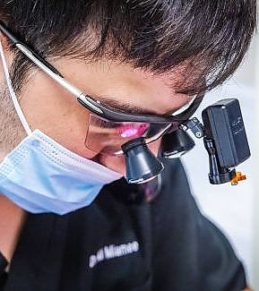 a man with a bandana and goggles on is using a cell phone  at RTC Dental in Arlington for Teeth whitening Reston services.