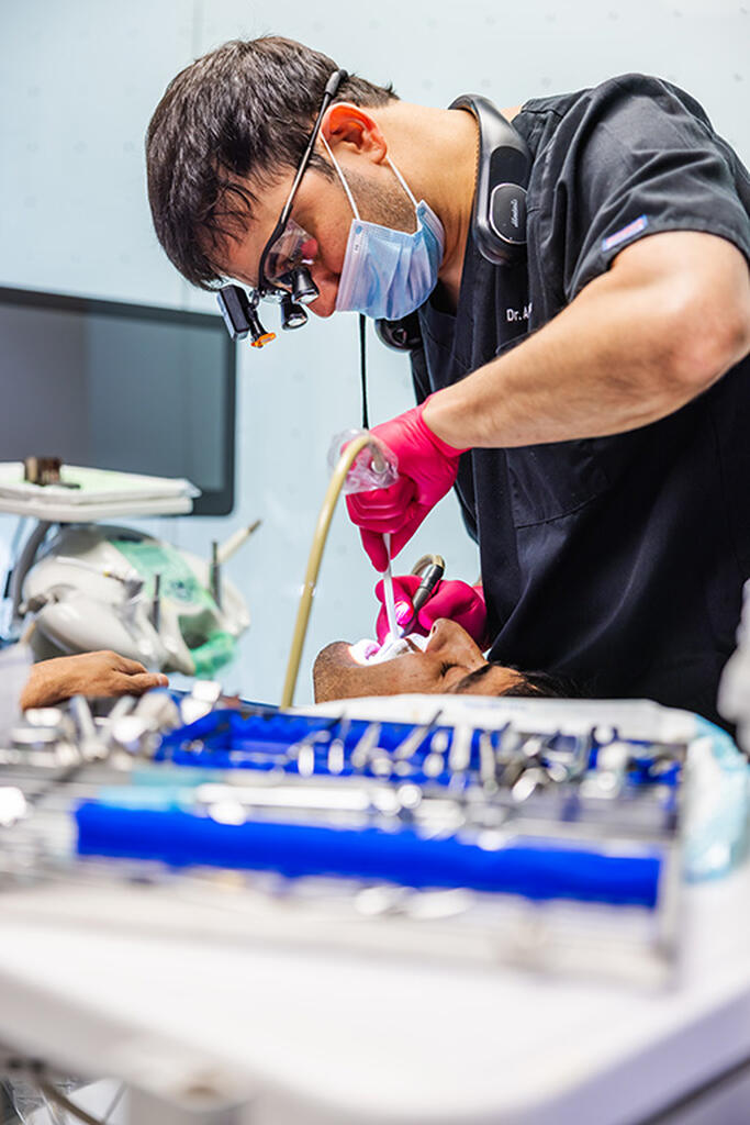 a man is fixing a pair of scissors  at RTC Dental in Reston, VA for Dentist Reston VA services.