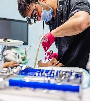 a man is fixing a pair of scissors  at RTC Dental in Reston, VA for Dentist Reston VA services.