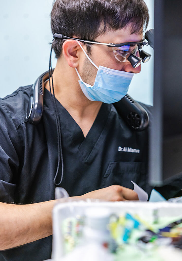  a man wearing a helmet and goggles is using a computer  at RTC Dental in Vienna for Family dentistry Reston services.