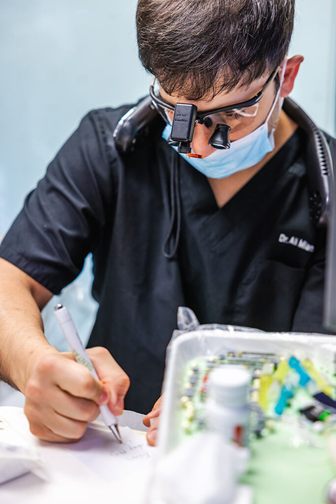 a man cutting a piece of paper with scissors  at RTC Dental in Sterling for Cosmetic dentist Reston services.