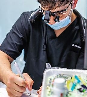 a man cutting a piece of paper with scissors  at RTC Dental in Sterling for Cosmetic dentist Reston services.