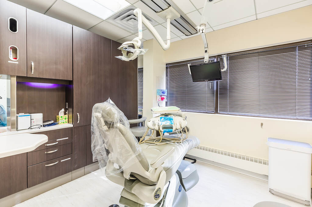 a hospital room with a bed and a monitor  at RTC Dental in McLean for Invisalign Reston services.