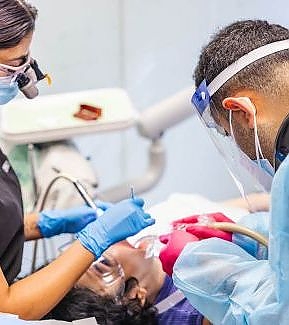 a nurse is cutting a patient's neck  at RTC Dental in Chantilly for Pediatric dentist Reston services.